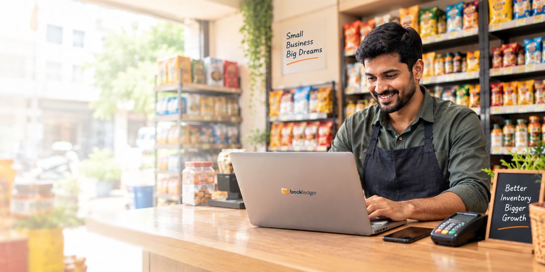A shop owner at the counter of their grocery store, working on a laptop running bookledger, with a card machine and phone beside them.